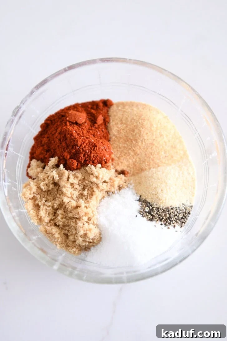 Quick and Tender Air Fryer Pork Tenderloin 3 A selection of essential spice rub ingredients – smoked paprika, garlic powder, onion powder, brown sugar, salt, and pepper – artfully arranged in a small glass bowl.