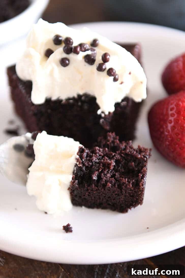 Velvety Chocolate Olive Oil Cake 13 Fork with bite of chocolate olive oil cake and whipped cream.