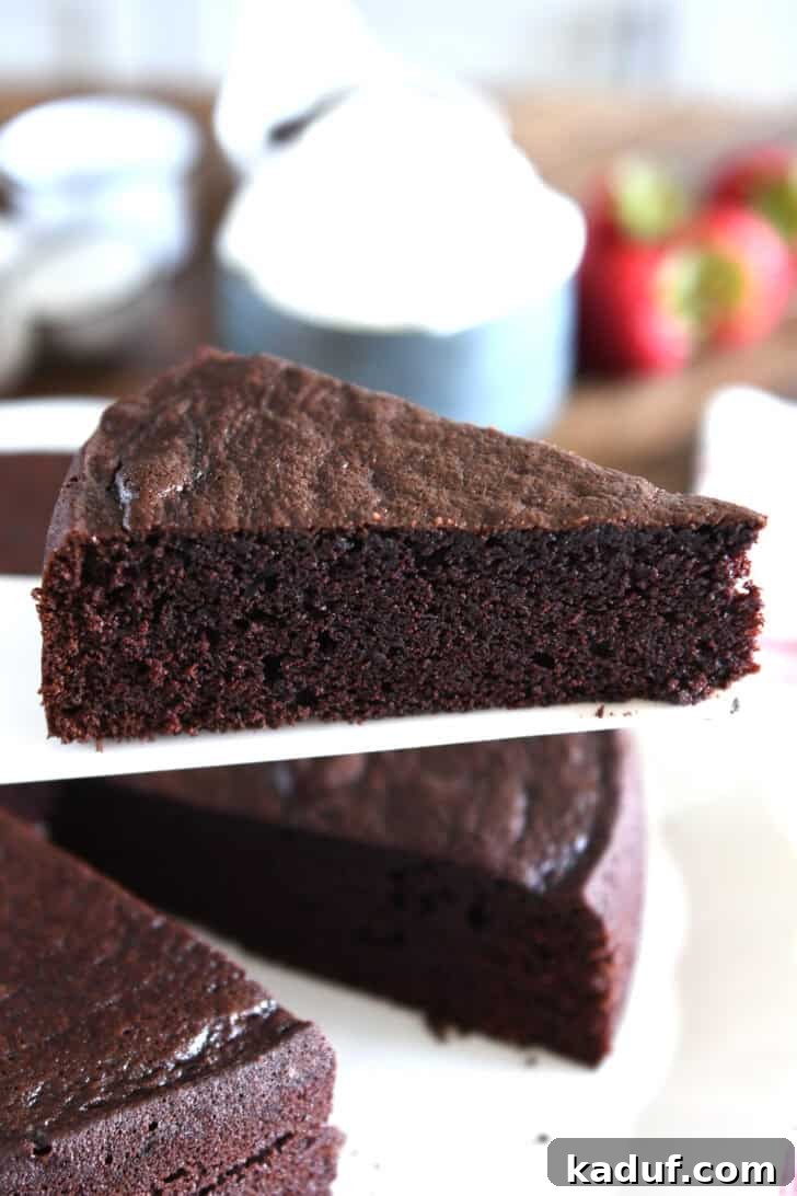 Velvety Chocolate Olive Oil Cake 3 Triangle slice of chocolate olive oil cake on white cake server.