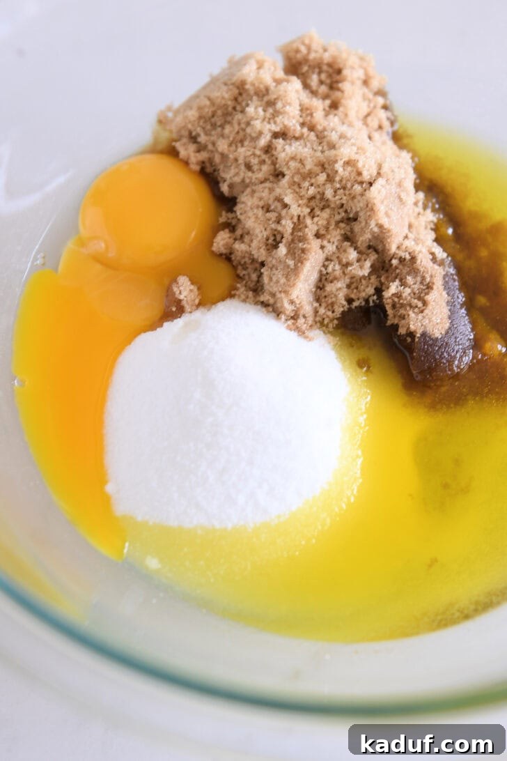 Velvety Chocolate Olive Oil Cake 6 Glass bowl with eggs, brown sugar, olive oil and granulated sugar.
