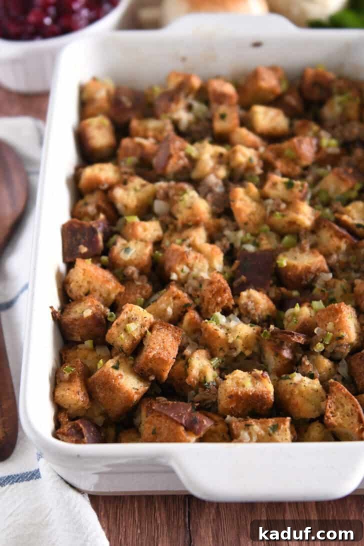Hearty Sausage and Herb Stuffing 2 Golden-brown sausage and herb stuffing baked in a white 9x13 inch pan, ready to serve.