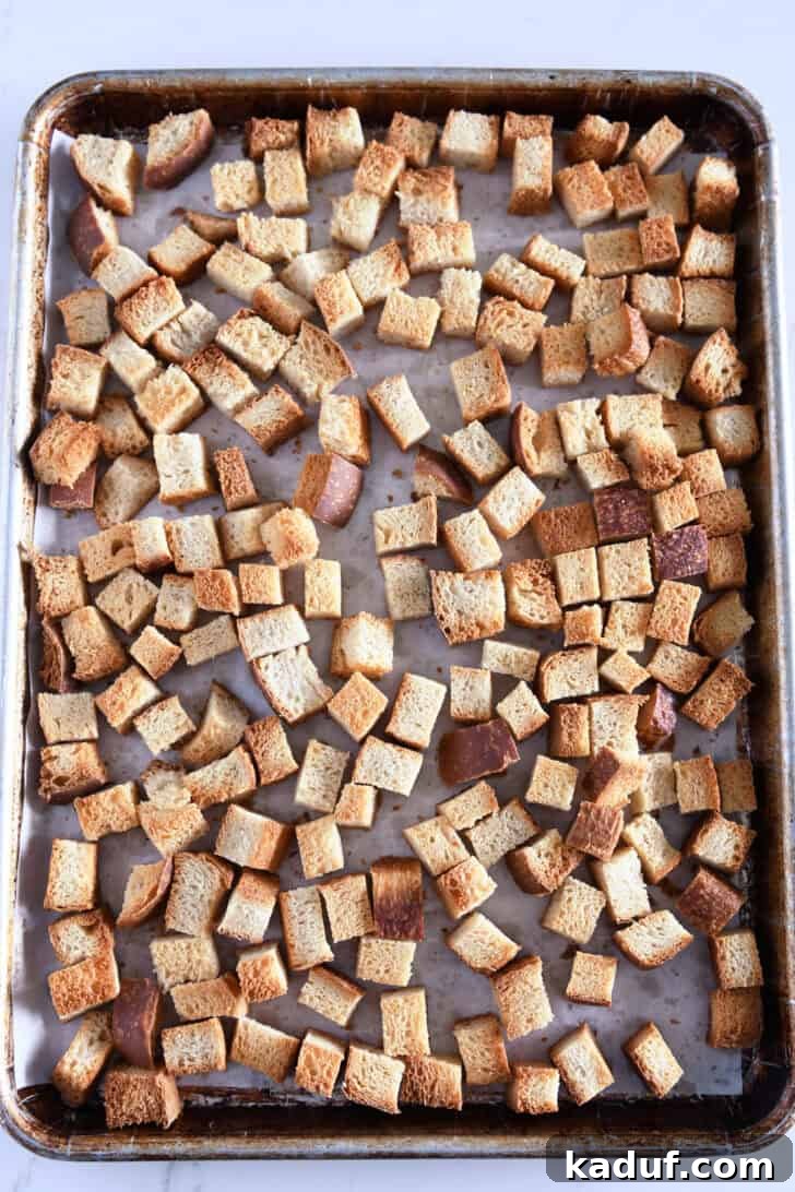 Hearty Sausage and Herb Stuffing 3 Sheet pan filled with evenly toasted, golden-brown bread cubes, ready for the stuffing mixture.