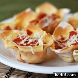 Ultimate Pizza Skillet Dip 4 Hot Pizza Dip Bites in wonton cups on a white plate.