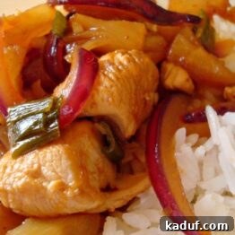 Zesty Pineapple Chicken with Crisp Red Onion 3 A close-up of Sweet and Sour Chicken with Pineapple and Red Onion served with white rice.