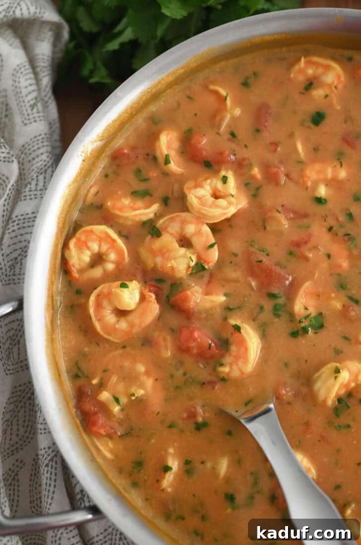 Creamy Coconut Shrimp Curry 9 Top down view of a metal pot full of a vibrant shrimp curry, ready to be served.