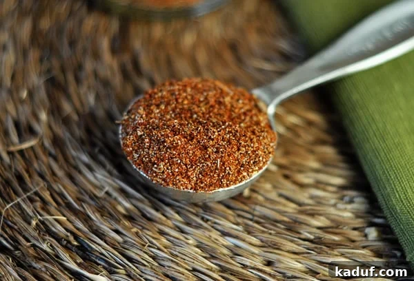 Signature Homemade Taco Blend 2 Homemade taco seasoning mix in a tablespoon. A close-up shot highlighting the vibrant colors and fine texture of the spice blend, ready to be added to a dish.