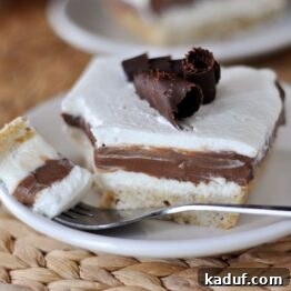 A slice of Robert Redford Dessert on a white plate, showcasing its distinct layers.