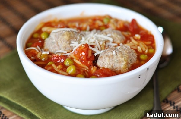 Hearty Meatball & Pasta Soup 3 Side view of a white bowl full of orzo and meatball soup.