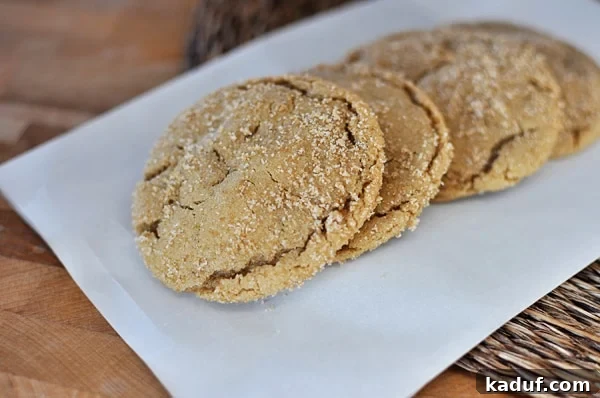 Chewy Brown Sugar Crackle Cookies 3 Four perfectly baked brown sugar crackle cookies arranged in a neat row, showcasing their signature cracked tops.