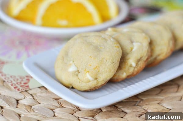 Velvet Orange Dream Cookies 2 White platter with white chocolate chip creamsicle cookies lined up on it.