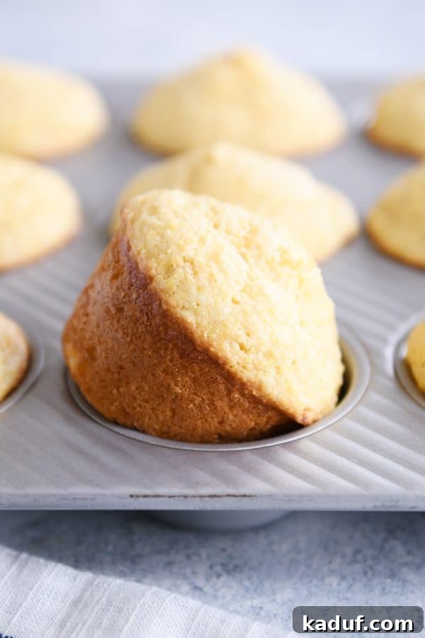 Fluffy Golden Cornbread Muffins 3 Baked cornbread muffin in pan.