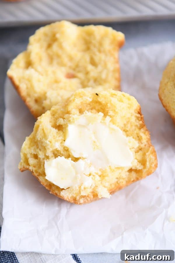 Fluffy Golden Cornbread Muffins 8 Cornbread muffin split in half with butter.