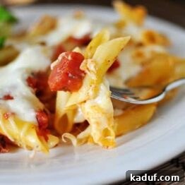 Classic Baked Pasta with Tomato and Mozzarella 4 Baked pasta with tomatoes and mozzarella in a white bowl.