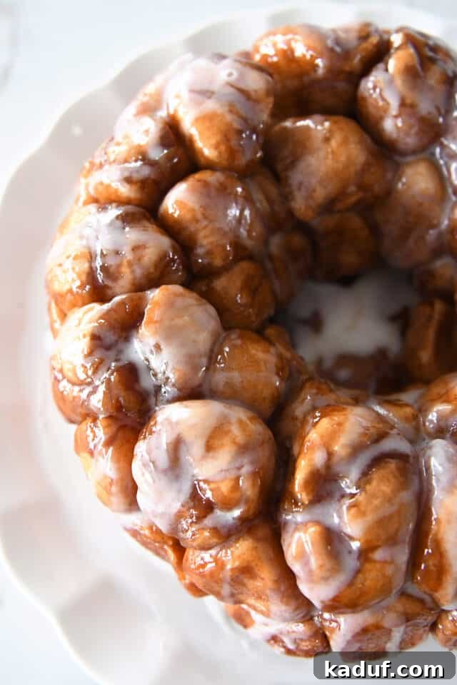 The Ultimate Sticky Pull Apart Monkey Bread 12 An inviting top-down view of the glazed pull-apart monkey bread on a pristine white tray, showcasing its sticky, sweet layers.