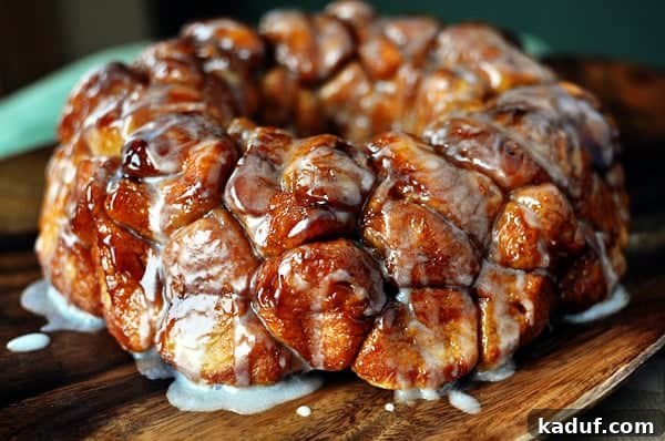 The Ultimate Sticky Pull Apart Monkey Bread 16 A glorious bundt-pan shaped monkey bread, with its cooked, gooey cinnamon-sugar pieces, rests on a wooden cutting board, ready to be devoured.