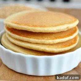 A close-up image of a perfectly cooked whole wheat blender pancake, with a rich golden-brown hue and delicate texture, suggesting its fluffiness and inviting taste.