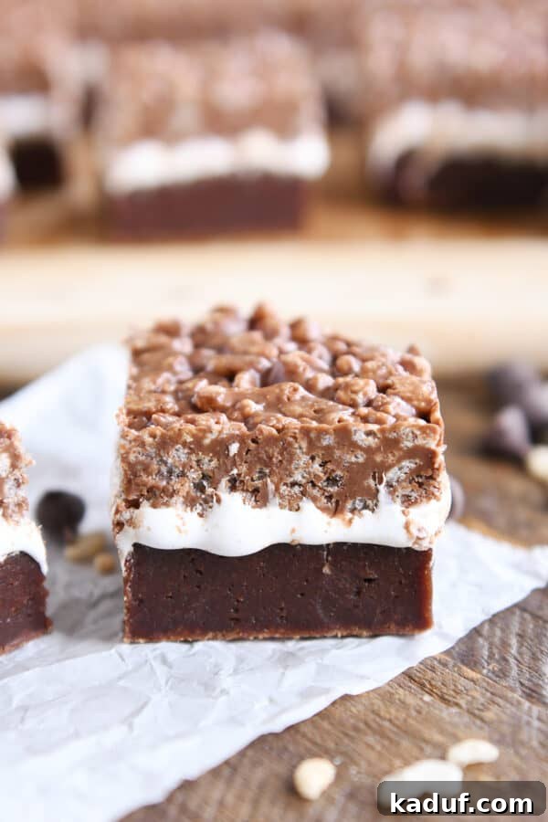 Ultimate Crunch Brownies 11 A single Killer Crunch Brownie resting on a white piece of parchment paper, highlighting its deliciousness and inviting texture.