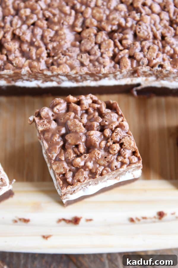 Ultimate Crunch Brownies 3 Individual Killer Crunch Brownie square on a rustic wood cutting board, ready to be enjoyed.