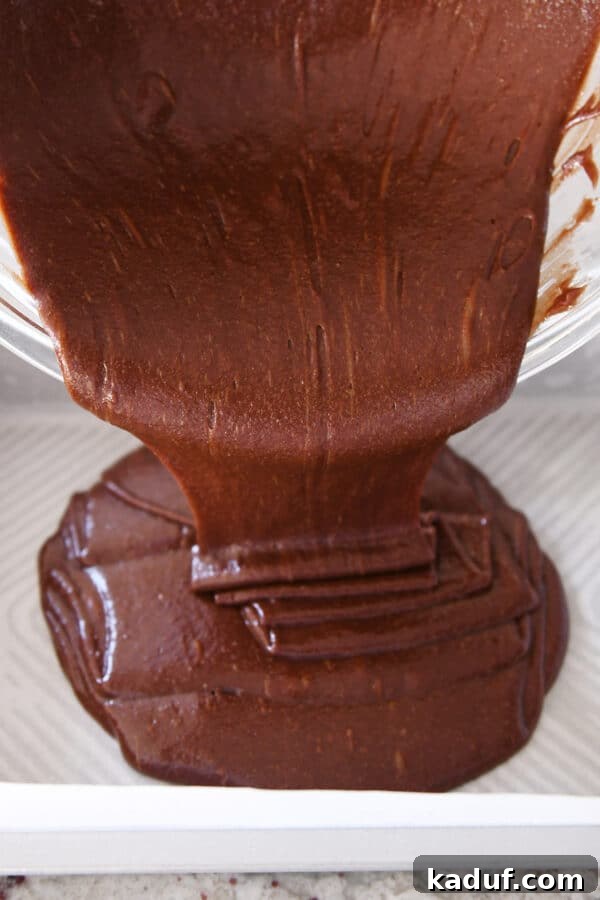Ultimate Crunch Brownies 5 Pouring rich brownie batter evenly into a 9x13-inch pan, ready for baking.