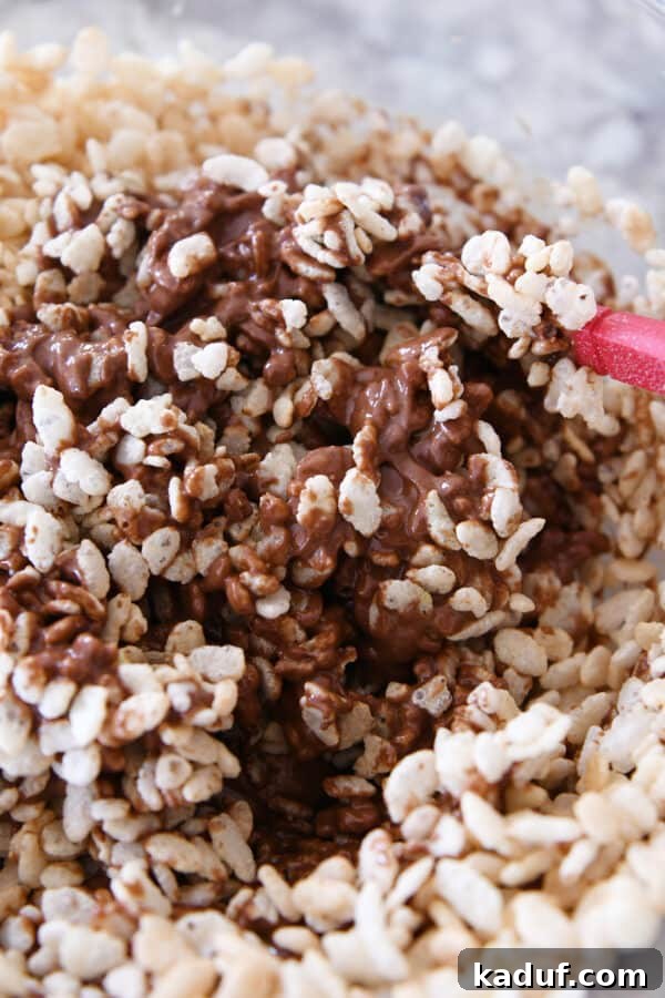 Ultimate Crunch Brownies 7 Stirring crisp rice cereal into a warm, melted mixture of peanut butter and chocolate, ensuring an even coating for the crispy topping.