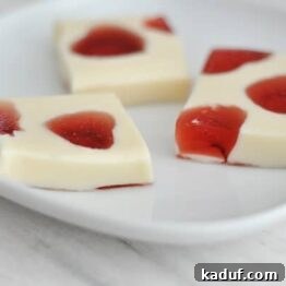 Vibrant red and white mosaic heart Jello jigglers on a white plate, a perfect Valentine's Day treat.