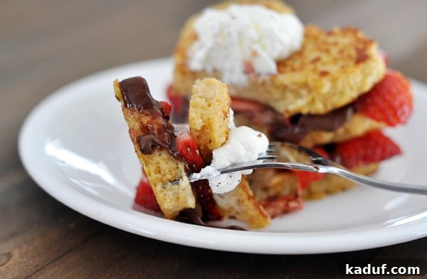 Strawberry and Nutella Bliss French Toast 3 Chocolate and strawberry stuffed french toast with a fork taking a bite out.