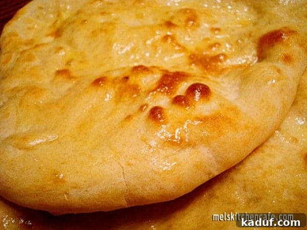 Pillowy Naan Perfection 2 Delicious homemade naan bread, cooked to golden perfection, ready for dipping in curry.