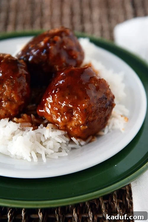 Tatlı Ekşili Köfteler 2 Several meatballs covered with sweet and sour sauce on white rice.