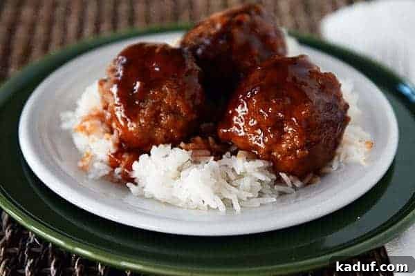 Tatlı Ekşili Köfteler 3 Sweet and sour meatballs over white rice on a white plate.
