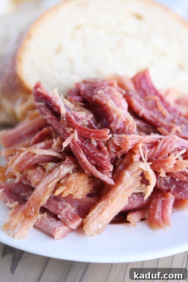 Sweet Glazed Baked Ham 12 Close up of sweet baked ham on white plate with bread.