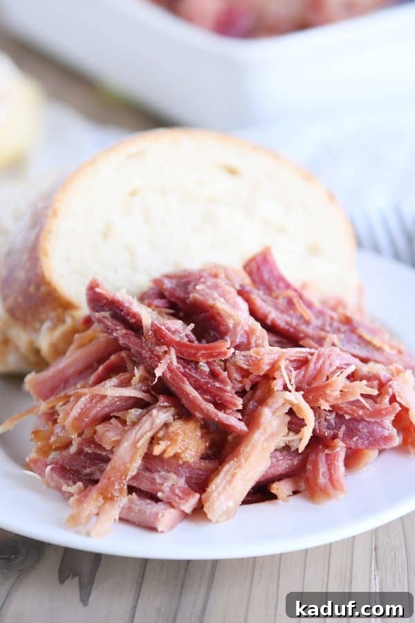 Sweet Glazed Baked Ham 3 Pile of sweet baked ham on white plate with bread.