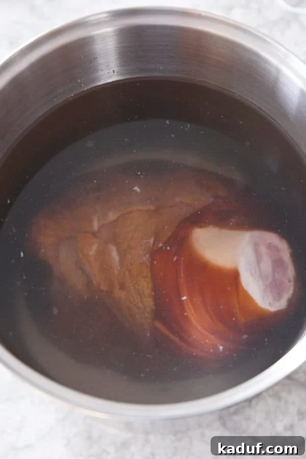 Sweet Glazed Baked Ham 4 Bone-in ham in pot with vinegar and water.