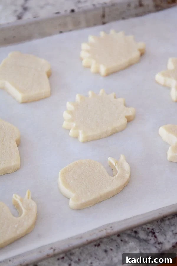Velvet Cloud Sugar Cookies 4 White sugar cookies cut out in various shapes all sitting on a piece of parchment paper.