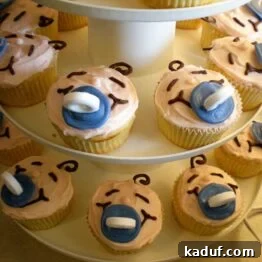 Close-up of a decorated buttermilk cupcake with cream cheese frosting, ready for a baby shower celebration.