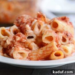 A close-up of a serving of Classic Baked Ziti, showcasing the rich sauce and melted cheese, garnished with fresh herbs.