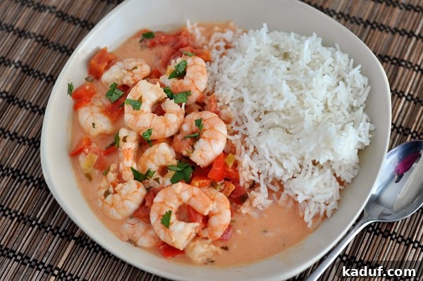 Garlic Shrimp Skillet with Coconut Lime Tomato Sauce 4 Top view of cooked shrimp bathed in a tomato sauce mixture with cooked white rice on the side.