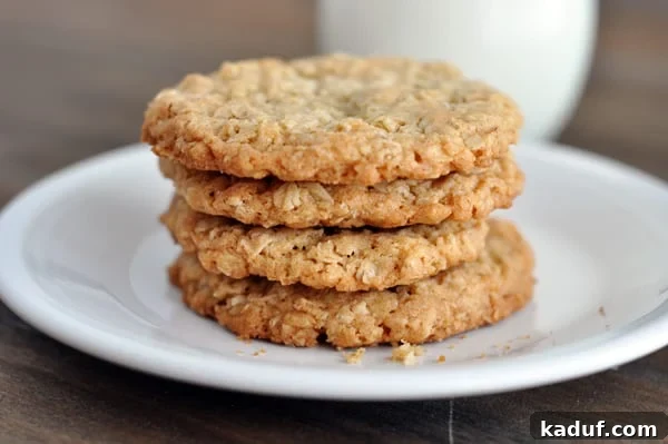 Chewy Oatmeal Lace Cookies 9 Four thin and crispy oatmeal cookies stacked on top of each other on a white plate.