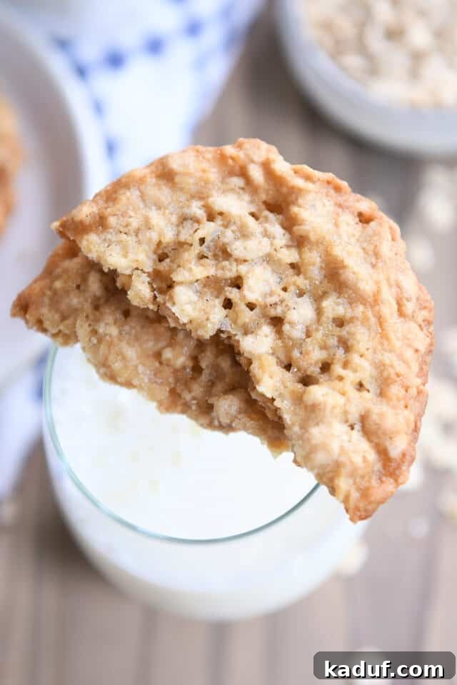 Chewy Oatmeal Lace Cookies 6 Two oatmeal cookie halves sitting on rim of glass of milk.