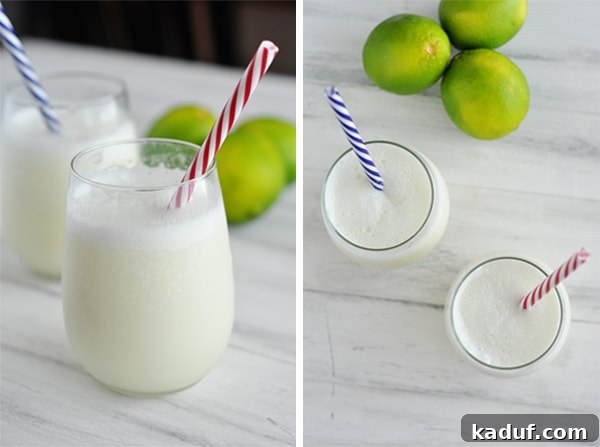 Velvet Brazilian Lemonade 3 Two glasses of creamy, frothy Brazilian Lemonade (limeade) with colorful striped straws, surrounded by fresh whole and sliced limes, emphasizing its vibrant and refreshing qualities.