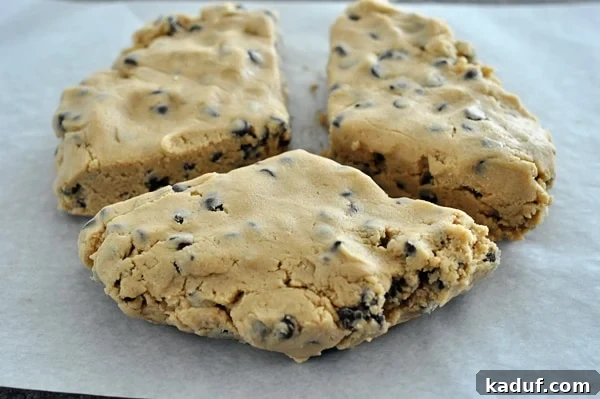 Three chunks of chocolate chip cookie dough on parchment paper, illustrating the different portions for chilling.