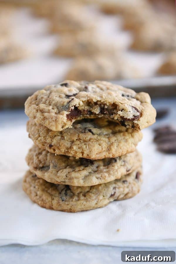 Chewy Oatmeal Chocolate Chip Cookies 6 A few freshly baked oatmeal chocolate chip cookies on a white napkin, ready to be eaten.