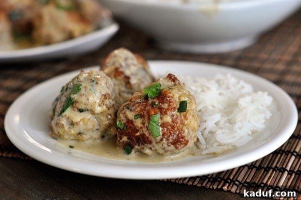 Vibrant Thai Green Curry Meatballs 4 Three sauce-covered meatballs and cooked white rice on a plate.