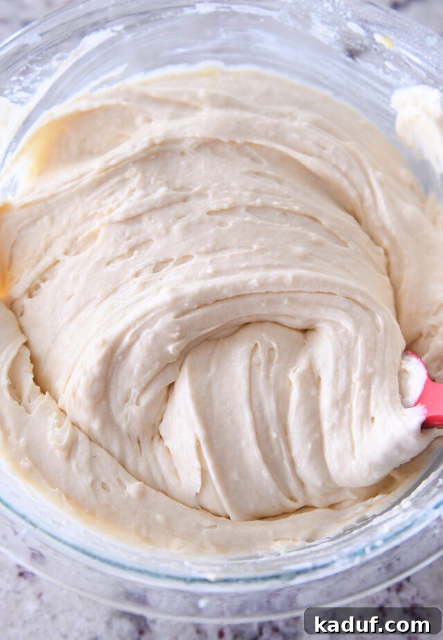 Indulgent Cinnamon Swirl Cake 4 Smooth vanilla cake batter, beautifully swirled in a clear glass bowl, showcasing its light and airy consistency.