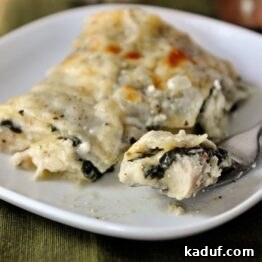 Creamy Chicken and Spinach Lasagna 4 A small image of a white plate with a piece of chicken and spinach lasagna.