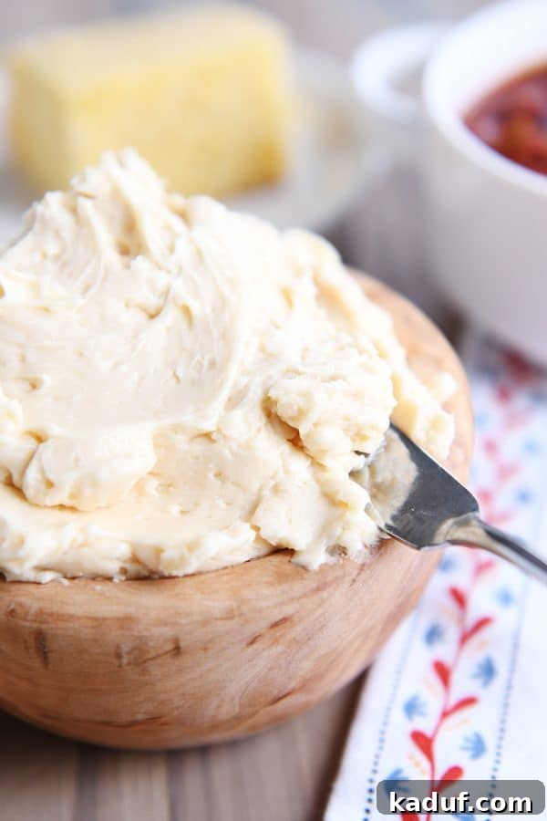 The Ultimate Cornbread with Cloudlike Honey Butter 8 A generous dollop of fluffy honey butter, perfectly whipped and ready to serve, presented in a rustic wooden bowl.