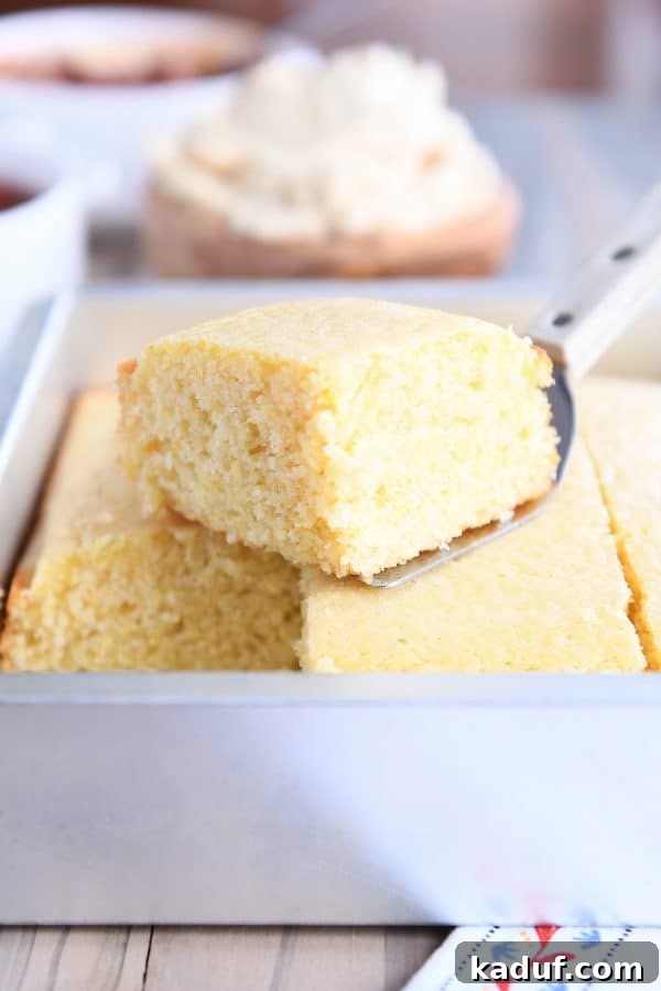 The Ultimate Cornbread with Cloudlike Honey Butter 10 A perfect slice of golden cornbread carefully lifted from the baking pan with a spatula, ready to be served.
