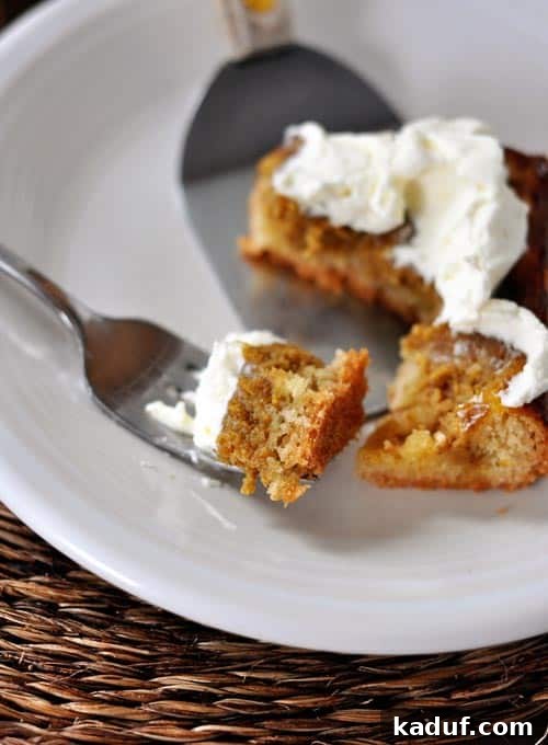 Sheet Pan Pumpkin Pie Heaven 4 A close-up shot of a fork taking a bite out of a soft, golden slice of Pumpkin Sheet Cake, revealing the creamy pumpkin filling and tender crust.