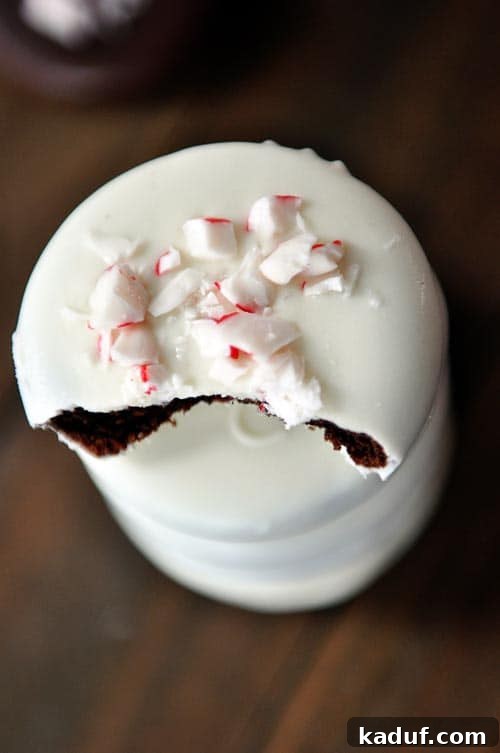Mint Chocolate Crisp Perfection 4 White chocolate dipped cookie with crushed candy canes on top and a bite taken out.