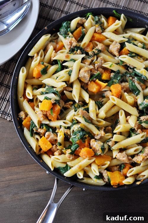 Skillet Sausage and Butternut Penne 2 A skillet full of tube pasta, golden butternut squash, fresh spinach, and savory chicken sausage, ready to be served.