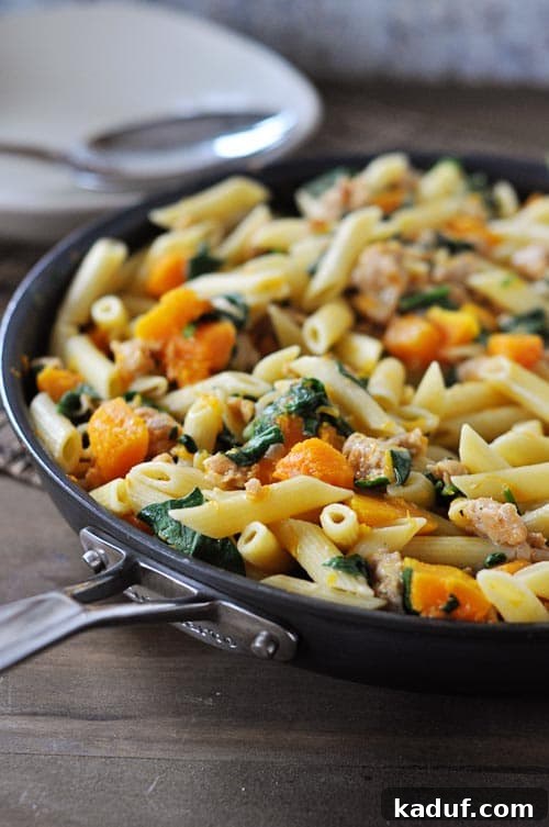 Skillet Sausage and Butternut Penne 4 Large skillet filled with creamy penne pasta, tender butternut squash cubes, wilted spinach, and browned chicken sausage.